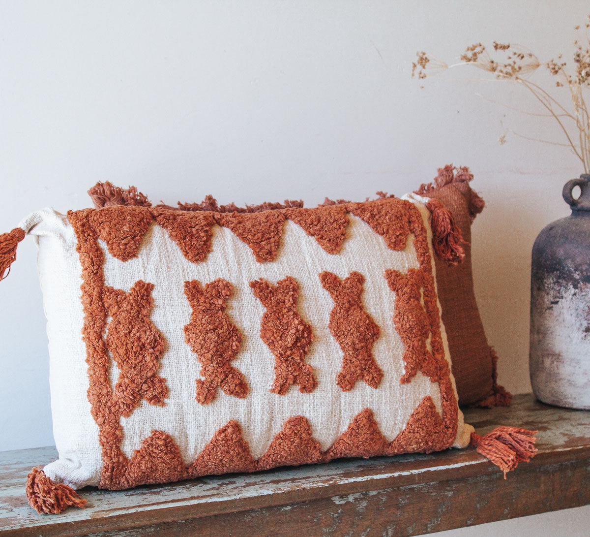 boho woven cotton rust coloured cushion with tufted embroidery and tassles