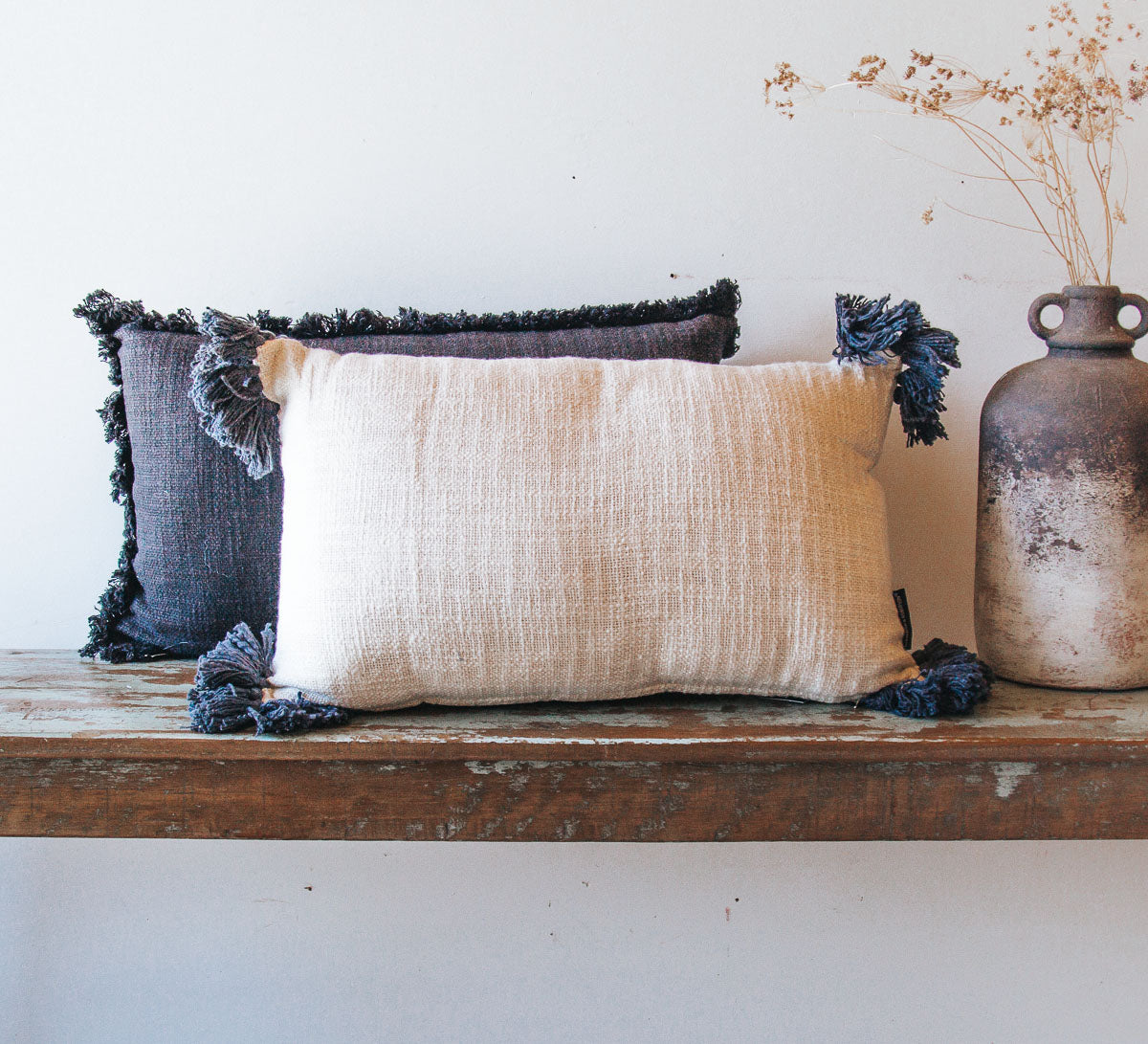 white oblong cotton boho cushion with navy tassles