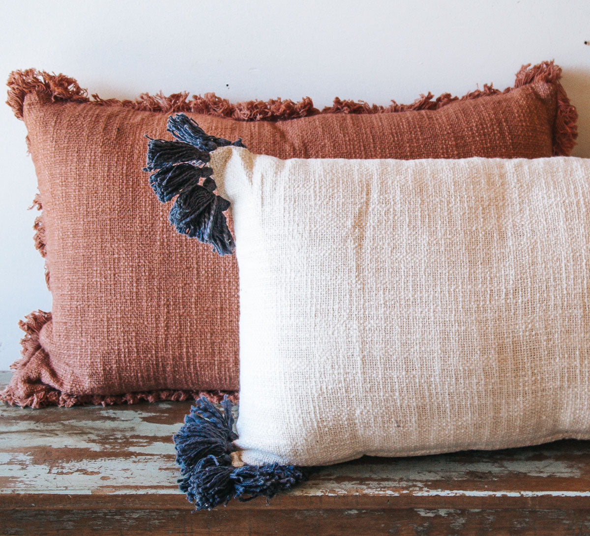 white oblong cotton boho cushion with navy tassles