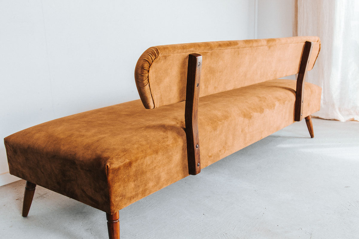 vintage boho mid century modern sofa with oak back and wooden legs.  upholstered in suede-like buttery soft mustard gold velvet couch