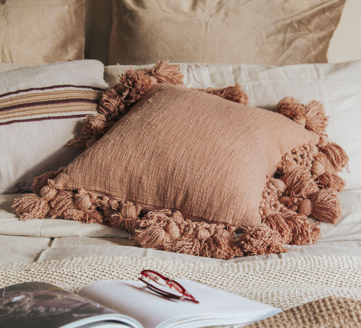 madam stoltz scandi boho cotton textured cushion with oversize tassles in burnt sugar soft blush pink throw pillow