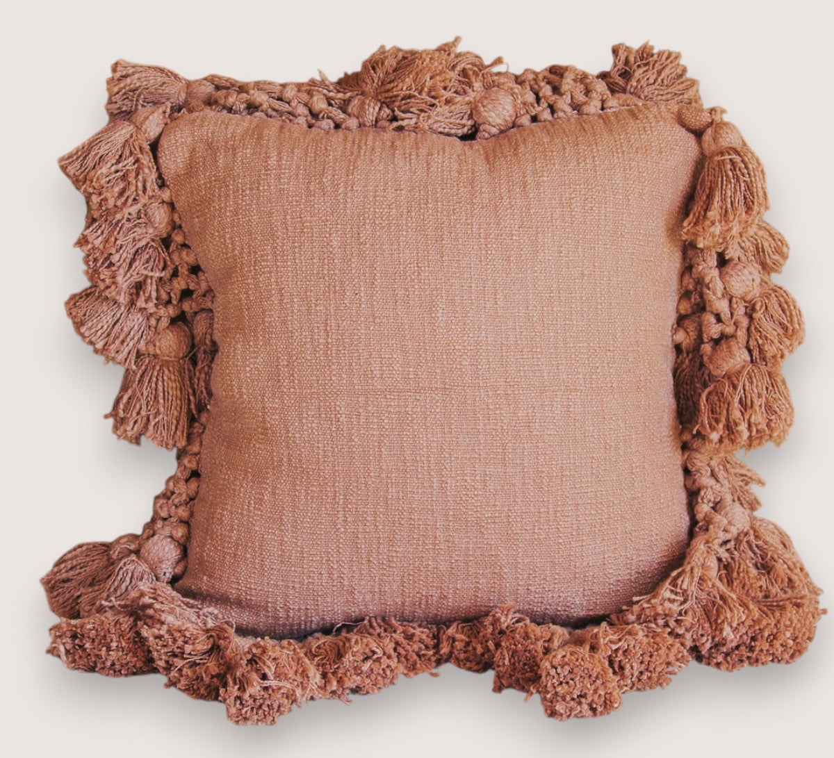 madam stoltz scandi boho cotton textured cushion with oversize tassles in burnt sugar soft blush pink throw pillow