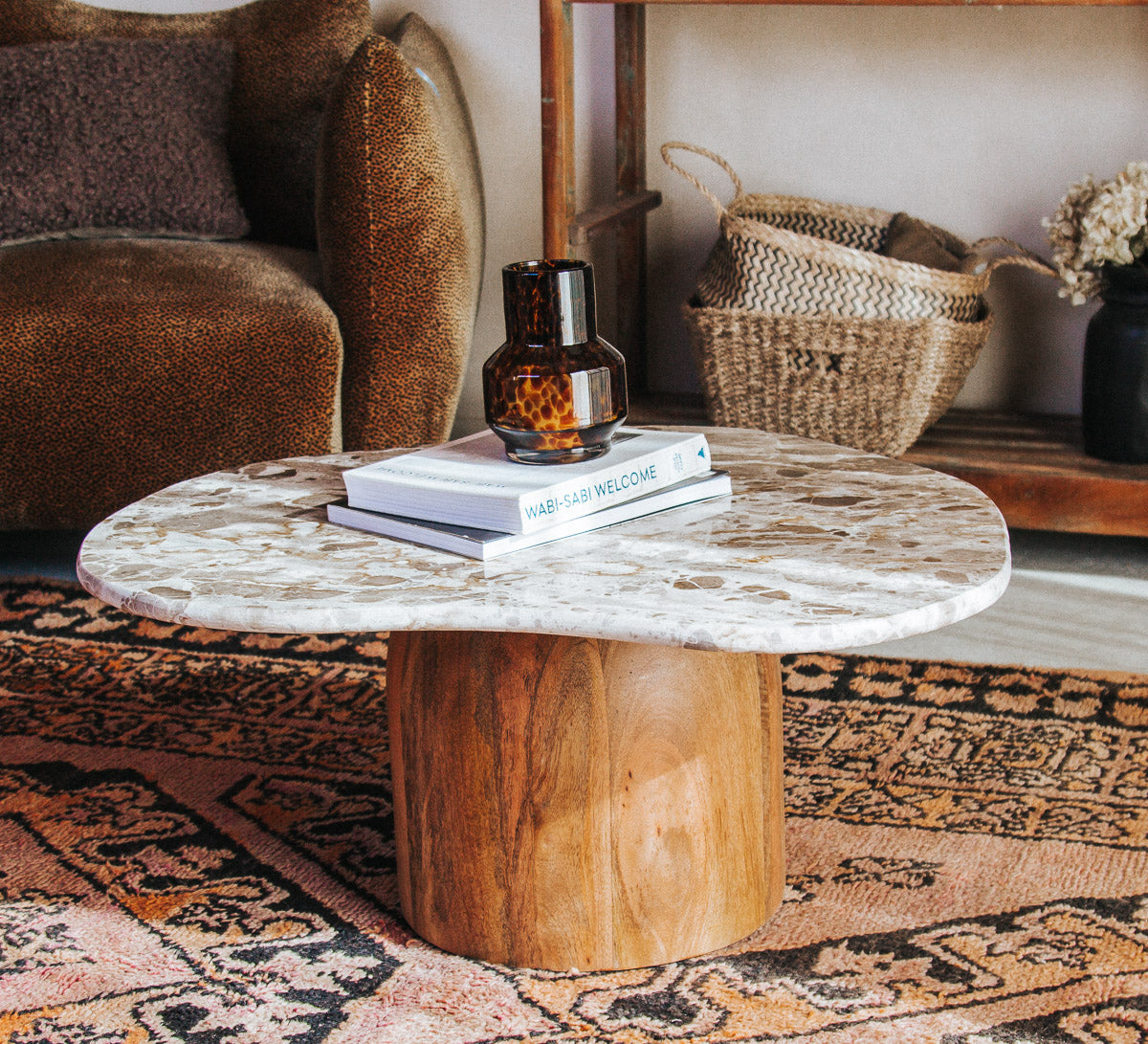 boho designer avi marble coffee table in an organic shape with a round curved solid wood base
