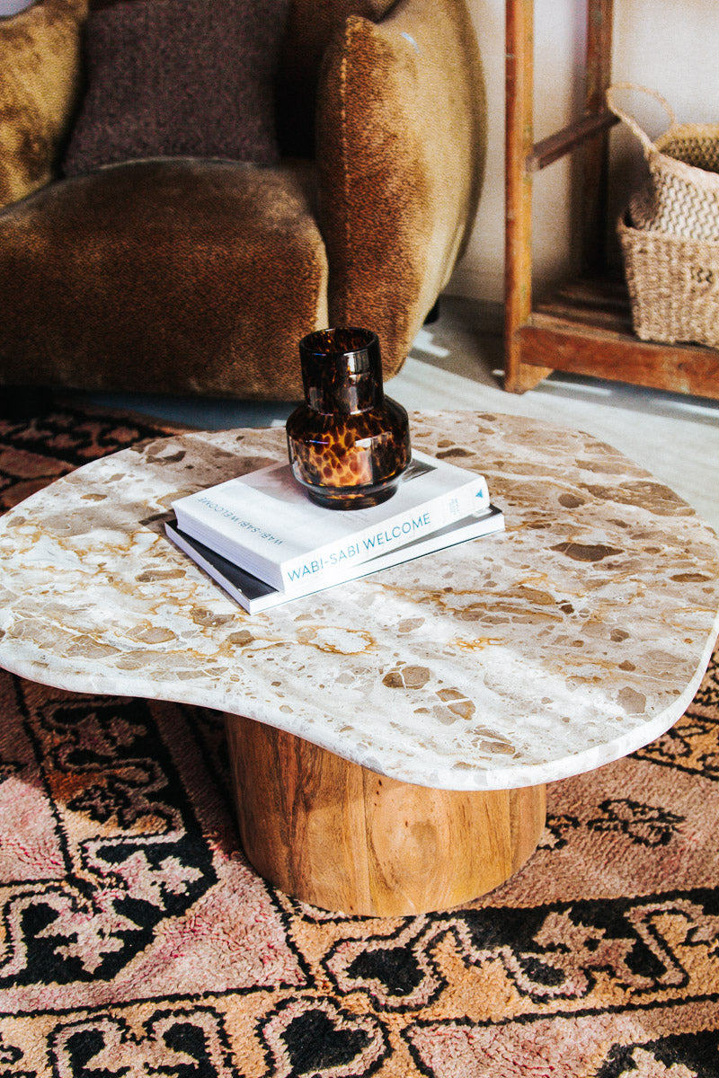boho designer avi marble coffee table in an organic shape with a round curved solid wood base