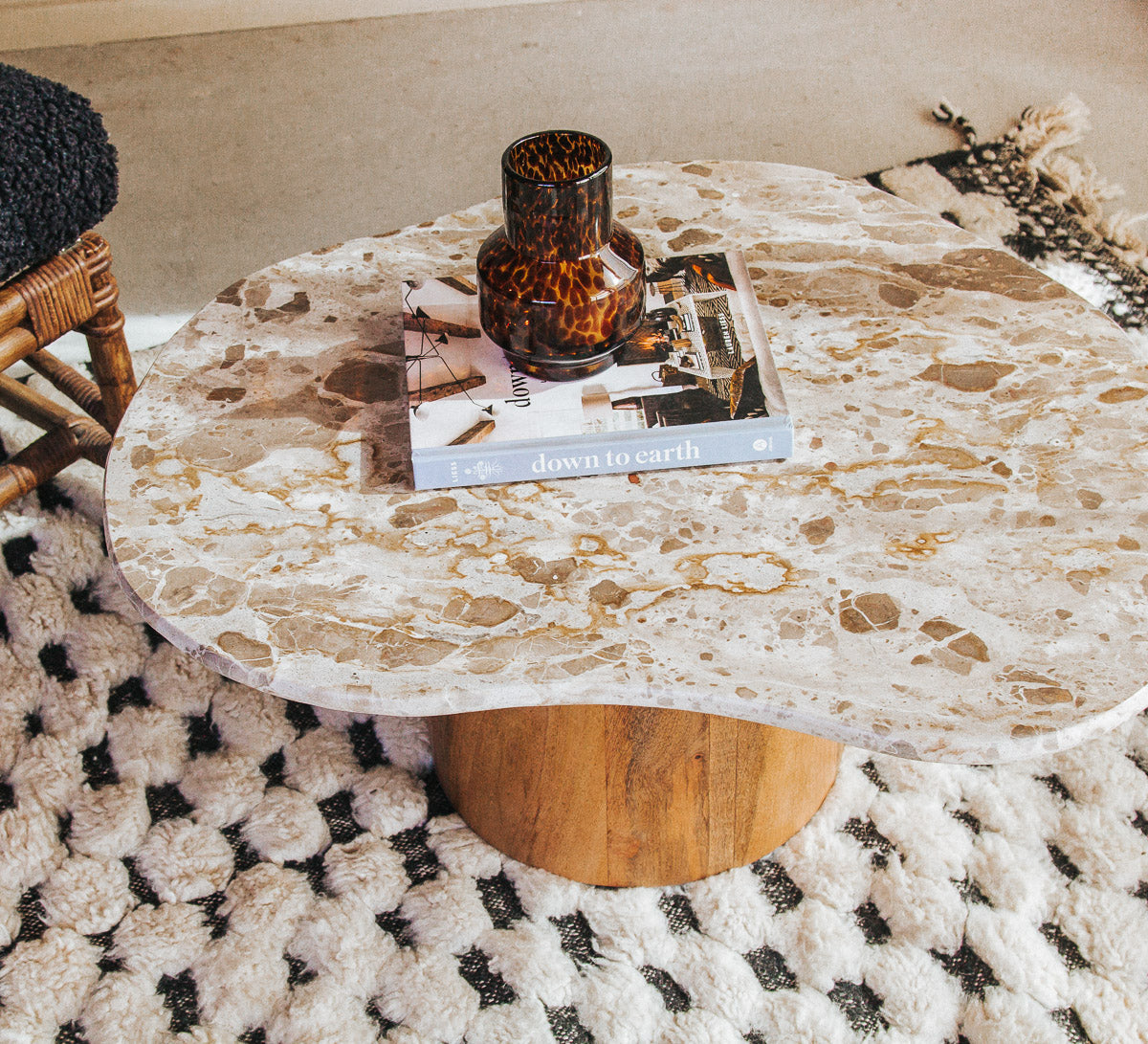 boho designer avi marble coffee table in an organic shape with a round curved solid wood base