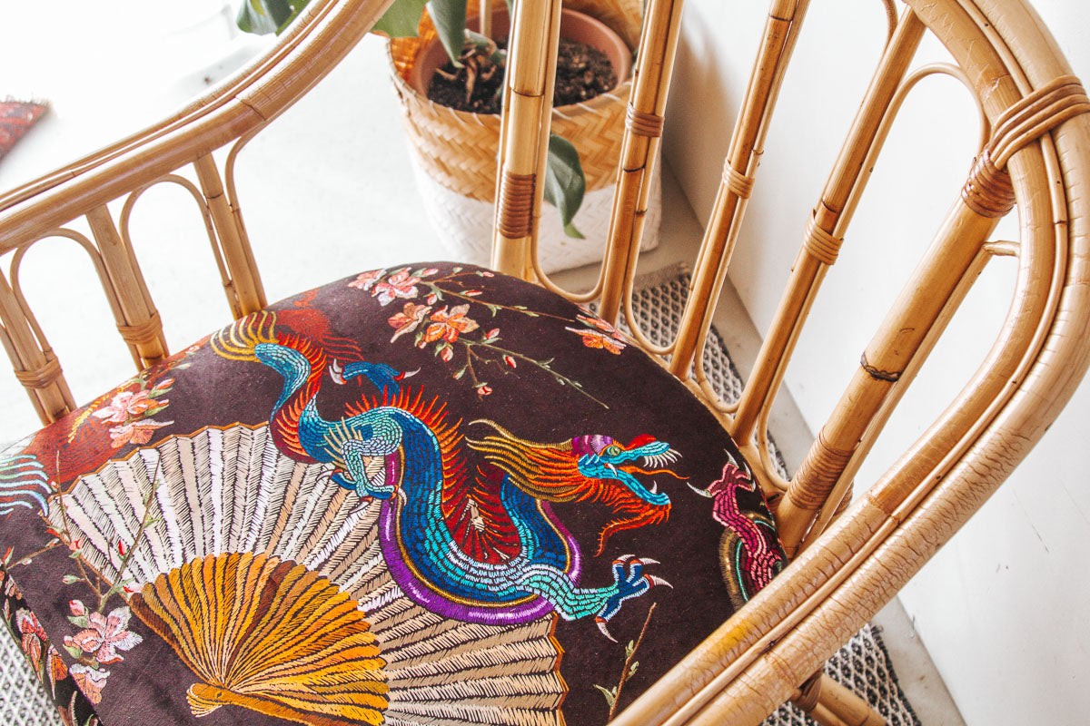 vintage boho cane armchair with black velvet dragon cushion