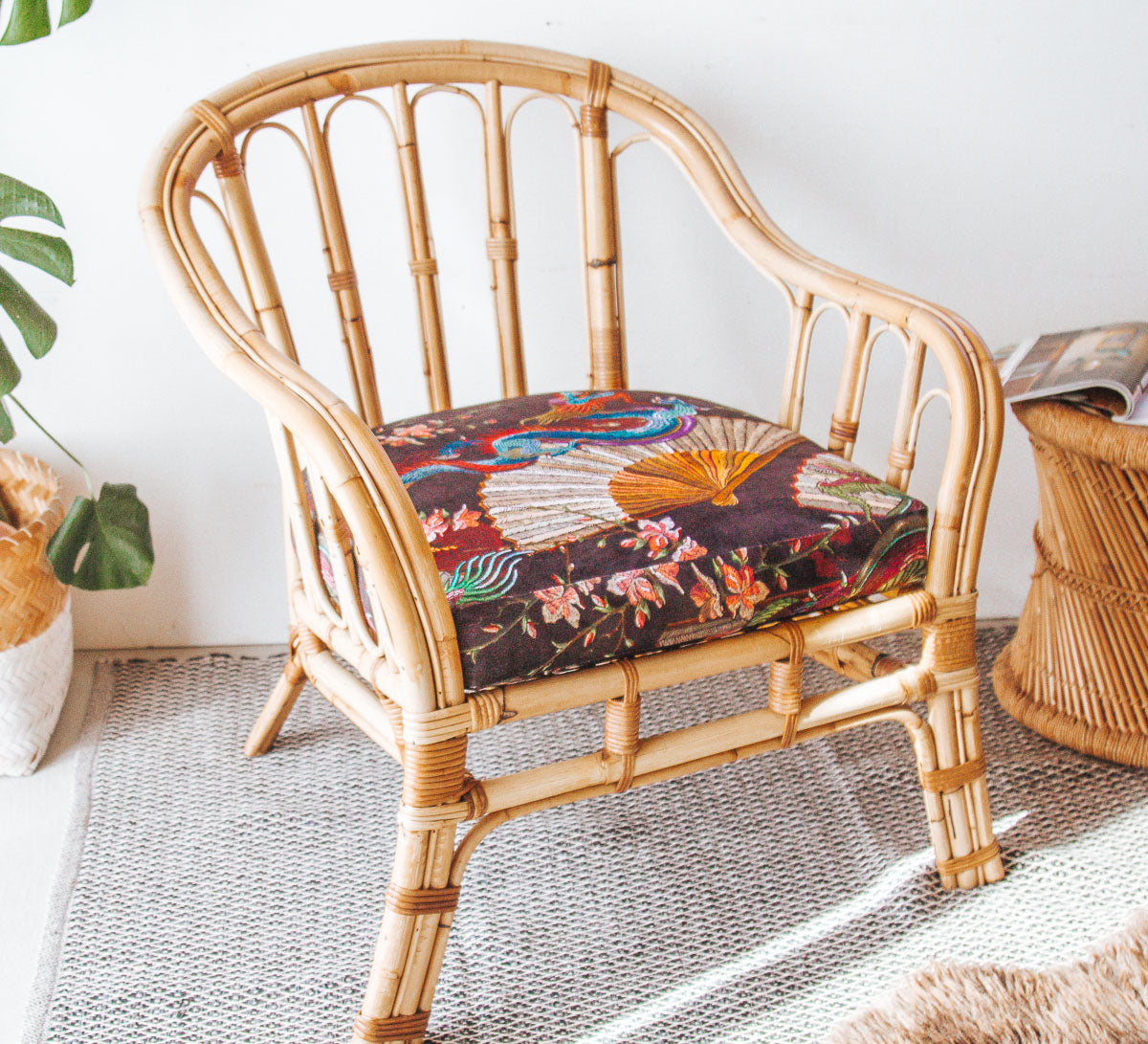 vintage boho cane armchair with black velvet dragon cushion